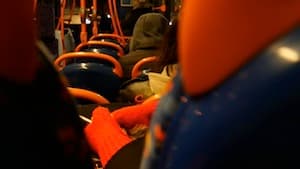 Inside the D bus at night a girl wears orange gloves